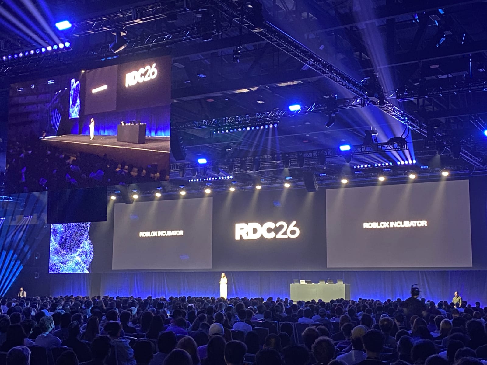 基調講演の会場。巨大なRDC26のロゴを囲む3面スクリーンと、会場を埋めつくす参加者